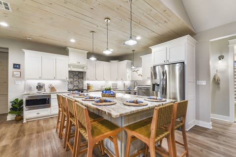 Kitchen with stainless steel appliances, gas range, mini bar.