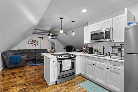 Your modern kitchen flows seamlessly into the cozy living area, where gleaming appliances and stylish fixtures create the perfect backdrop for memorable meals.