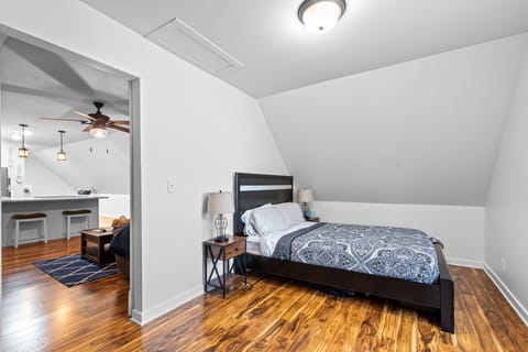 Your cozy bedroom features rich hardwood floors and thoughtful lighting, connecting seamlessly to the modern kitchen for ultimate comfort.