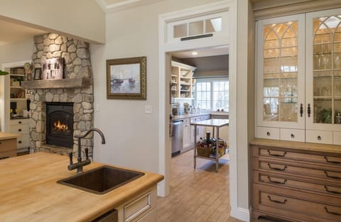 Kitchen Fireplace with View of Pantry which has another stove, refrigerator, and dishwasher