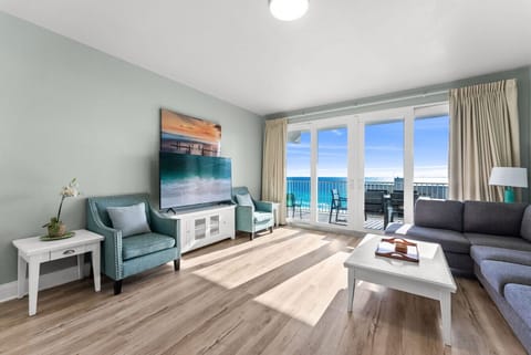 Coastal-themed living room with comfortable seating and direct access to the private Gulf-front balcony.