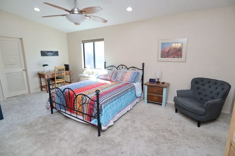 Queen size bed in spacious bedroom with desk