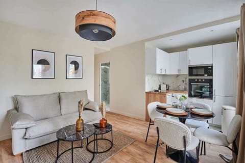 Salon avec canapé lit , cuisine américaine et coin repas