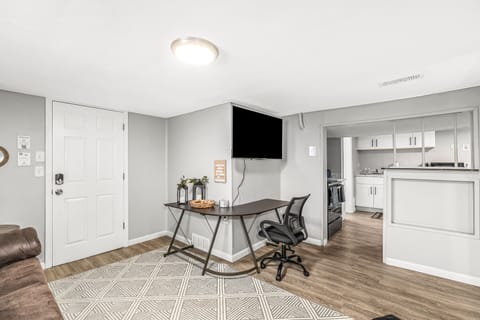 Work from home or relax in style in this spacious living room with a desk and a TV.