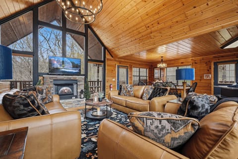 Sink into plush leather seating by your crackling fireplace, where warm wood surrounds you and stunning chandeliers create the perfect mountain retreat atmosphere.