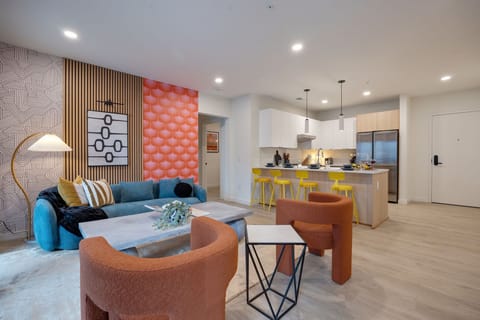 Bright open living space featuring SMART flat-screen TV, designer furnishings, and patio entrance with pool view.