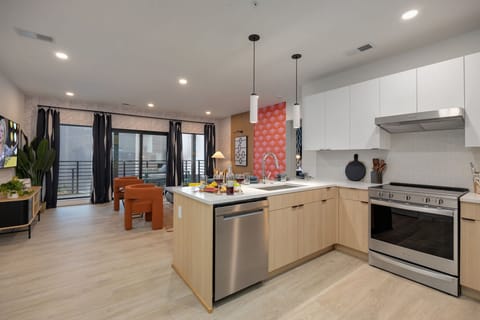Fully equipped modern kitchen stocked with all culinary essentials and featuring stainless steel appliances with island bar seating.