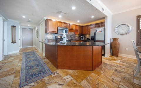 Cook and gather in the inviting kitchen featuring rich wood cabinetry and a spacious granite countertops for meal prep