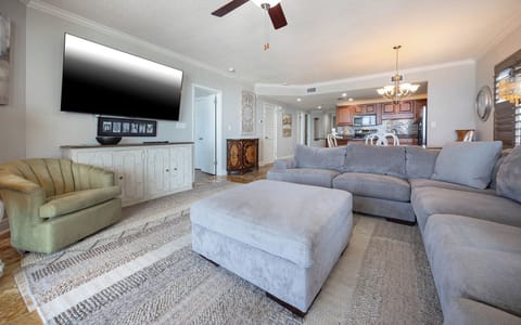 Relax in the inviting living area with plush seating, a large TV, and easy access to the dining and kitchen spaces