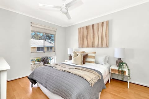The light and airy first bedroom includes a ceiling fan and is thoughtfully appointed with a queen bed, side tables and reading lamps. 
