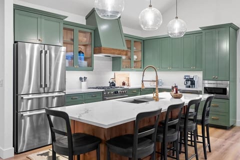 An expansive kitchen designed to elevate your cooking experience, equipped with top-of-the-line Bosch appliances and a spacious island, perfect for entertaining and preparing meals for a large group.