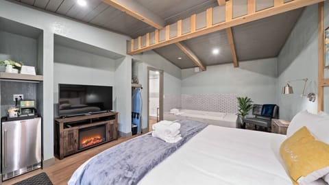 Bedroom with mini fridge, TV and Bathroom