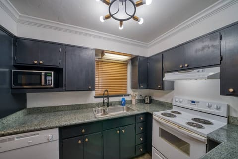 Kitchen with a four burner stove, oven and microwave.