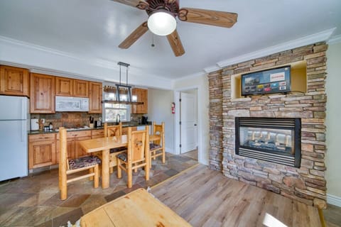Fully stocked kitchen with dining area off the living room which is equipped with a gas fire place and Smart TV with Netflix. View from the entryway.