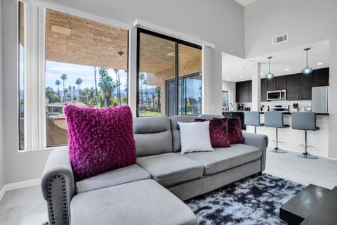 Comfortable living room seating with patio views and open kitchen access
