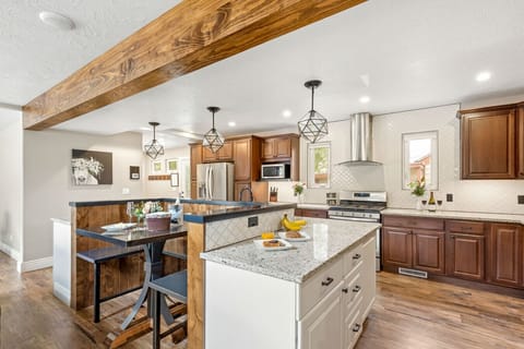 Spacious entertainer’s kitchen featuring a large prep island, wood-beam charm, and premium upgrades.