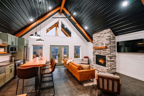 Soaring ceilings and an elegant stone fireplace along with a radiant heated floor make for a beautiful and cozy living room in any season 😊