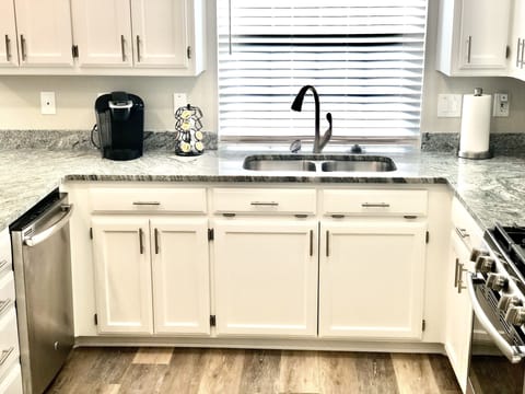 Kitchen with sink, dishwasher & keurig coffee maker with complementary pods.