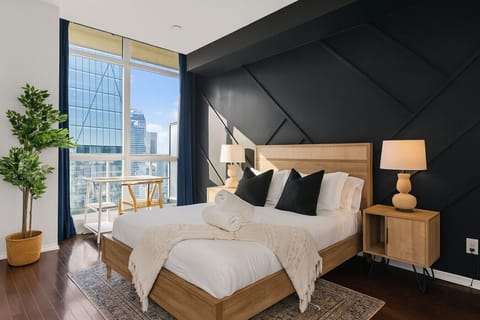 The master bedroom has a stunning accent wall and dedicated workspace overlooking the city.