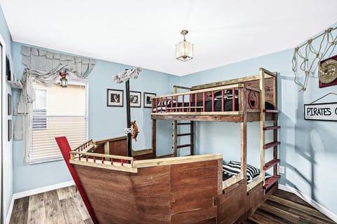 Set sail on an adventure in this pirate-themed bedroom, complete with a ship-shaped bunk bed and nautical decor. Perfect for young explorers!