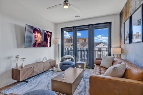 Bright living room with comfortable seating, smart TV, designer decor, and access to the private patio.