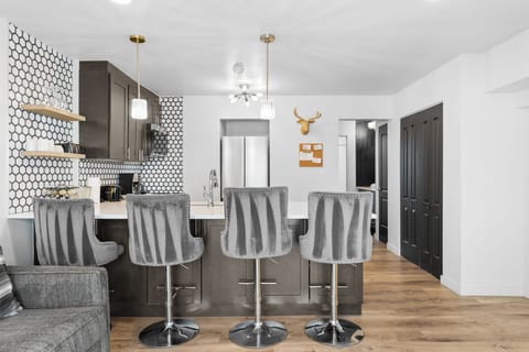 Full kitchen with stainless steel appliances, and breakfast bar.