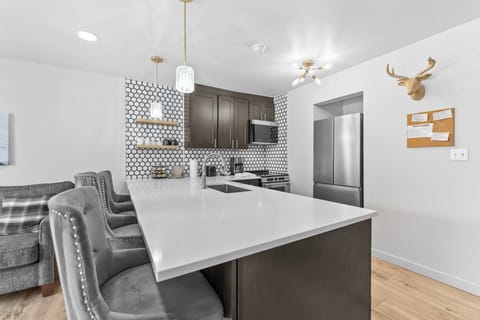 Full kitchen with stainless steel appliances, and breakfast bar.
