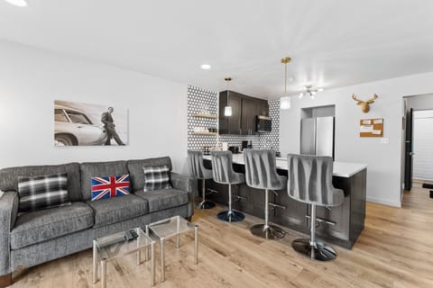 Living area with a mounted TV over a gas fireplace, a queen sleeper sofa, and balcony access.