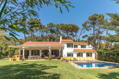 Holiday villa with surrounding garden and swimming pool.