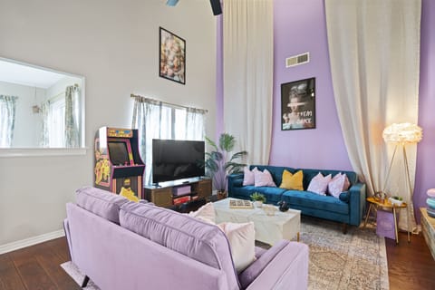 Gorgeous living room with sofa, tv, arcade game and curtain decors