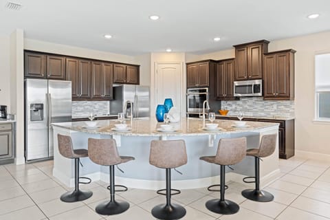 - Dual fridge kitchen with double ovens and curved island bar seating for six
- Family vacation rental feature ideal for groups traveling to Orlando Disney
- Plenty of cooking space and modern design create easy meal preparation time