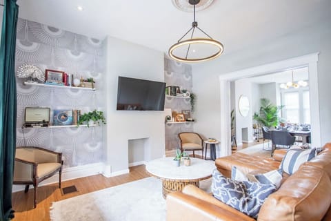 Cozy living room featuring a comfortable couch, a stylish center table, elegant décor, and a TV, creating a perfect space for relaxation and entertainment.