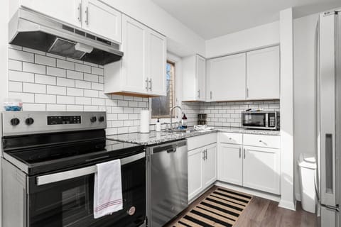The bright gallery style kitchen offers stainless steel appliances: fridge with freezer, electric stove & oven, dishwasher, microwave, & keriug coffee maker
