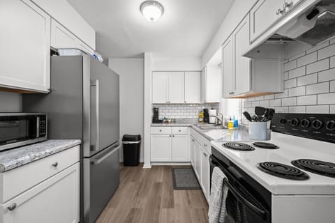 Cooking utensils, microwave, electric stove with oven, and plenty of extra cleaning supplies under the sink for your use