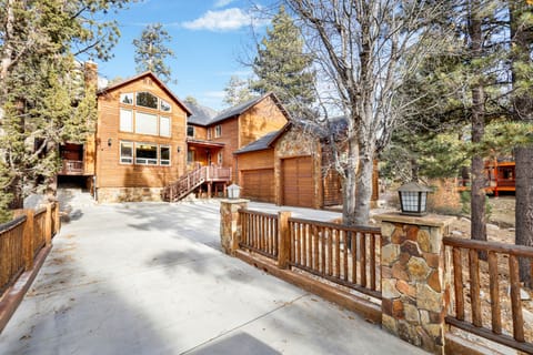 Welcoming cabin entry surrounded by towering pine trees, offering fresh mountain air and a peaceful forest setting—the perfect first impression for your Big Bear Lake getaway.