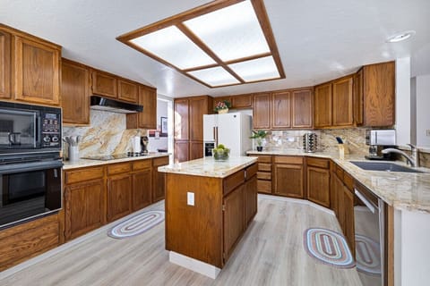 Wooden and modernly equipped kitchen with a skylight.