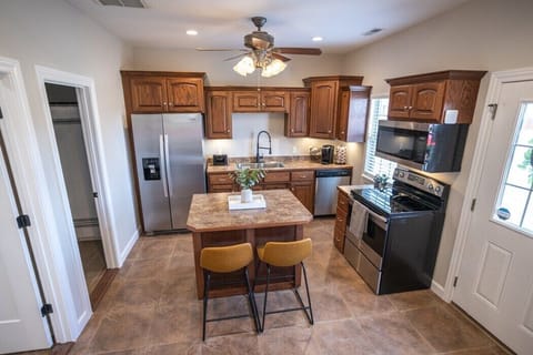 Fully stocked kitchen includes variety of cooking utensils & containers, coffee bar, movable island and bar seating.