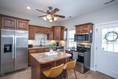 A robust, full service kitchen with cooking utensils, pots and pans, and a coffee bar.