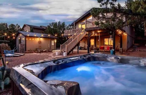 Forest view hot tub with jets, umbrella for day use, and mood lighting at night.