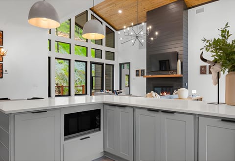 Our open-concept living space features large windows that invite nature to join your relaxation time by the fireplace.