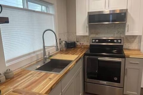 Kitchen featuring a brand-new cooking station and stainless-steel appliances