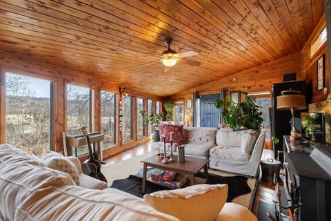 Spacious living room with a reading nook, TV, wood-burning fireplace and huge windows overlooking the Buffalo River. We also have a record player and Sonos speakers to play music.