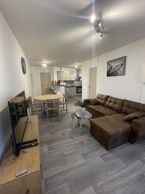 "La Feuillette living room with TV stand, leather sofa, coffee table and dining table"