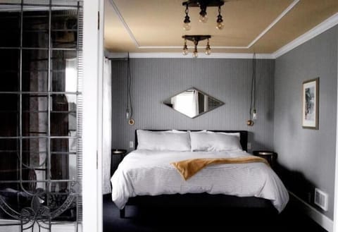 Settle into a serene bed beneath warm, glowing pendants.