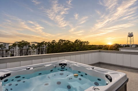 Soak in the rooftop hot tub with sweeping views—now elevated by soft sunset skies and a peaceful coastal horizon.
