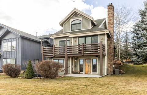 Back of home with trees surrounding the private sunken hot tub