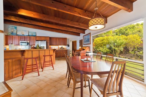 Casual dining area has a beautiful vintage table; there is also counter seating on bar stools Casual dining area, table and bar stools