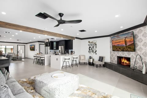 Bright open formal living space features a smart flat-screen TV, fireplace, and designer furnishings.