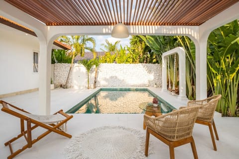 Shaded seating area overlooking the private pool and greenery