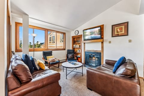 Living Room: 2 leather couches, 2 chairs, fireplace, TV, board games
